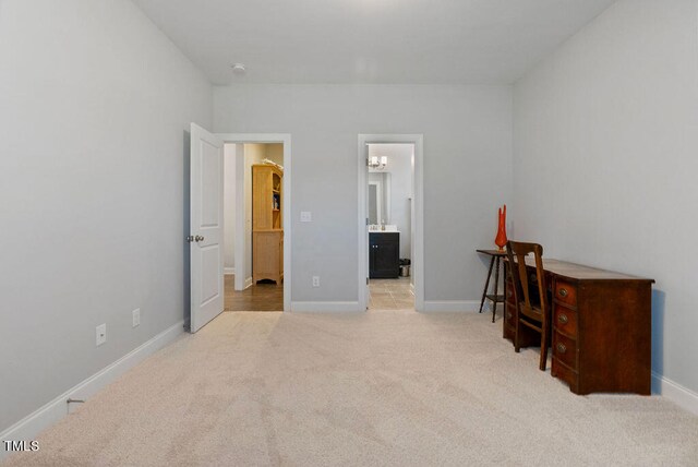 bedroom with light colored carpet and connected bathroom