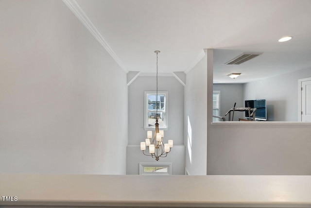 interior details featuring an inviting chandelier and crown molding