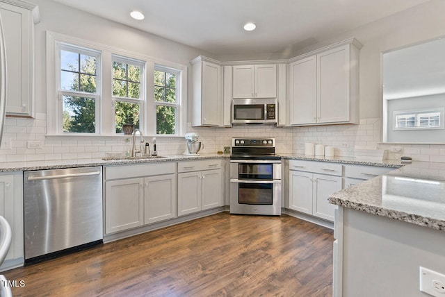 kitchen featuring stainless steel appliances, white cabinets, and sink