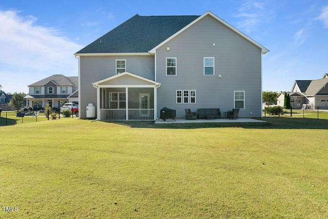 back of property featuring a patio, a yard, and a sunroom