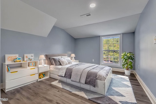 bedroom with dark wood-type flooring and lofted ceiling