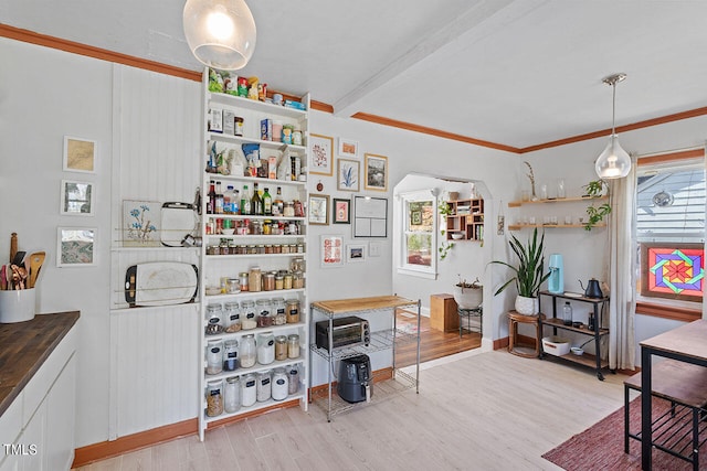 interior space with crown molding, beam ceiling, and light wood-type flooring