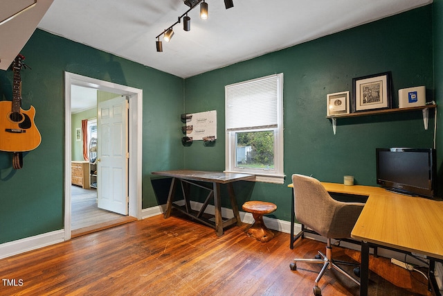 home office featuring hardwood / wood-style flooring and track lighting