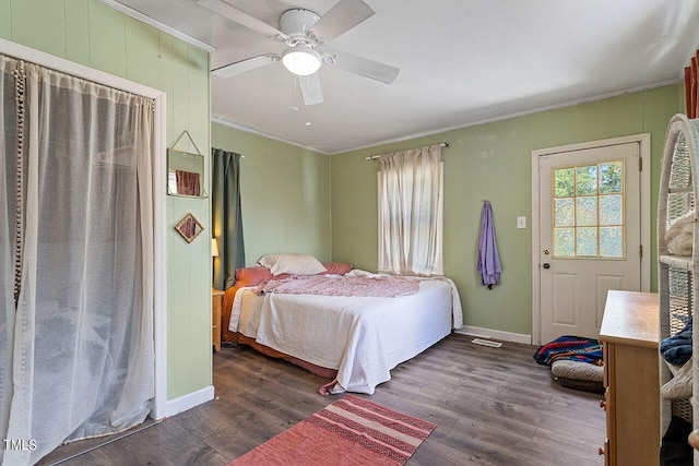 bedroom with ornamental molding, dark wood-type flooring, and ceiling fan