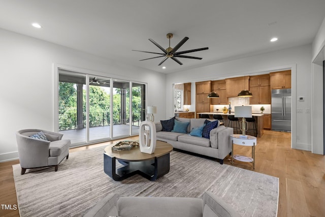 living area with a ceiling fan, light wood-type flooring, and recessed lighting