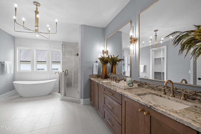 bathroom with a chandelier, a shower stall, double vanity, a freestanding tub, and tile patterned floors