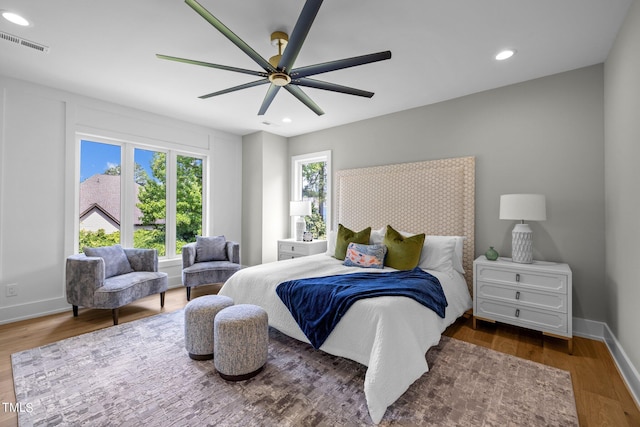 bedroom with multiple windows, recessed lighting, wood finished floors, and baseboards