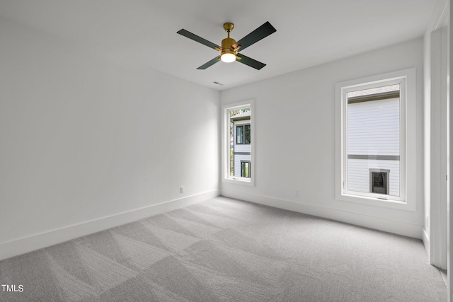 spare room featuring carpet flooring, baseboards, and a ceiling fan