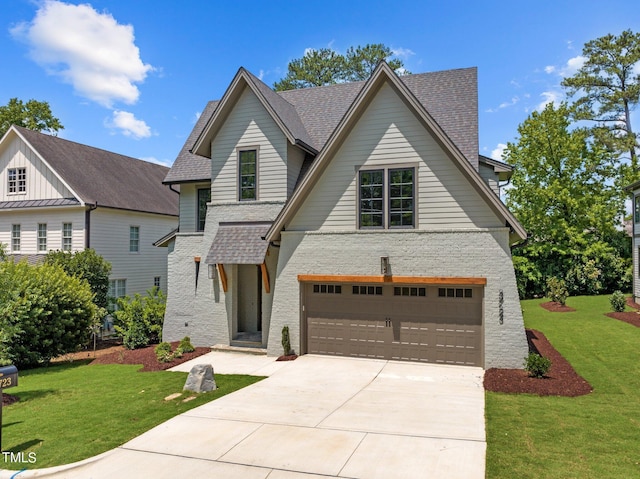 view of front of home featuring a front yard, driveway, an attached garage, and a shingled roof