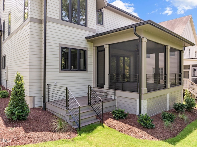 rear view of property featuring a sunroom