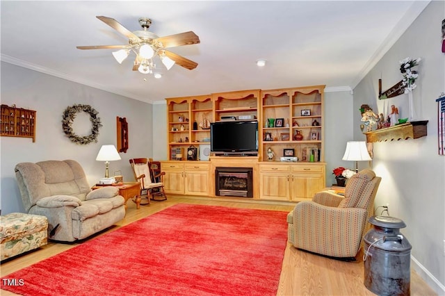 living room featuring crown molding, light hardwood / wood-style floors, and ceiling fan