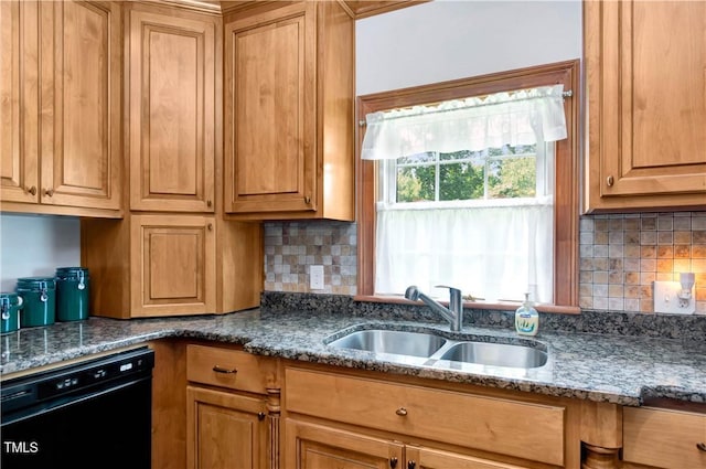 kitchen with black dishwasher, sink, decorative backsplash, and dark stone counters