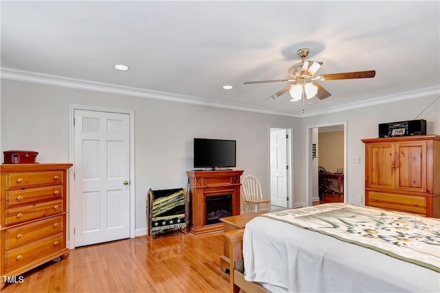 bedroom with ceiling fan, ornamental molding, and light hardwood / wood-style flooring