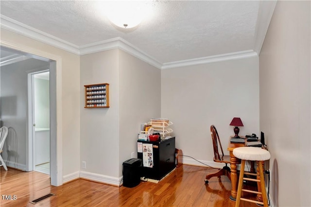 home office featuring crown molding, wood-type flooring, and a textured ceiling