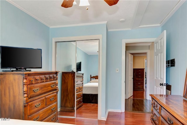 bedroom featuring hardwood / wood-style floors, crown molding, a closet, and ceiling fan