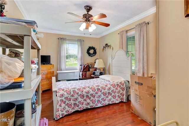 bedroom featuring dark hardwood / wood-style flooring, crown molding, and ceiling fan