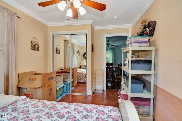 bedroom featuring a closet, ceiling fan, ornamental molding, and dark hardwood / wood-style flooring