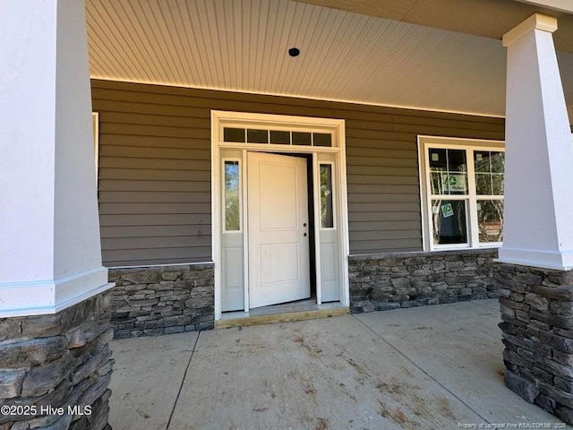 view of exterior entry featuring covered porch