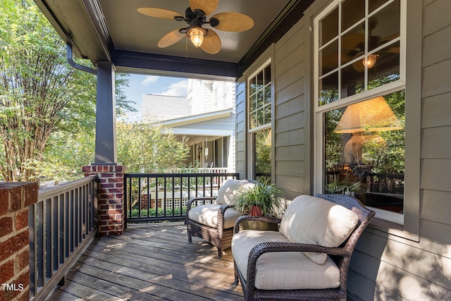 wooden deck featuring covered porch and a ceiling fan