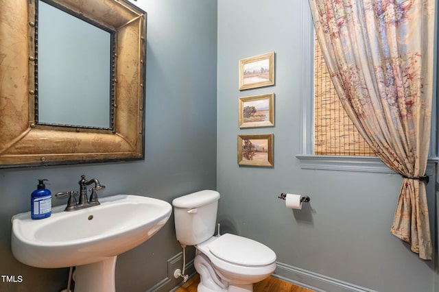 bathroom with toilet, sink, and hardwood / wood-style floors