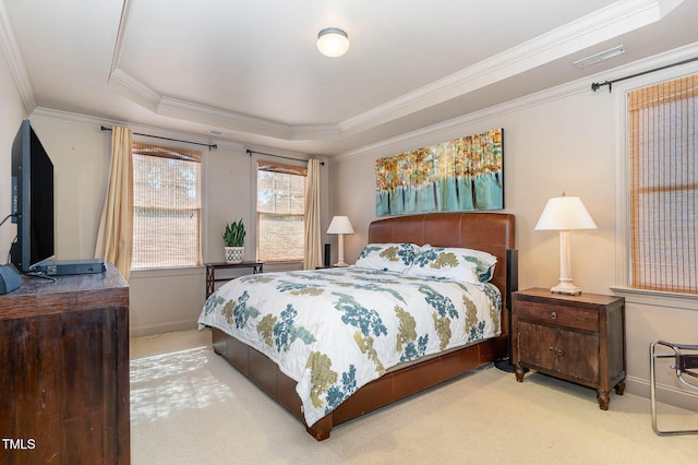 bedroom with carpet floors, a tray ceiling, crown molding, visible vents, and baseboards