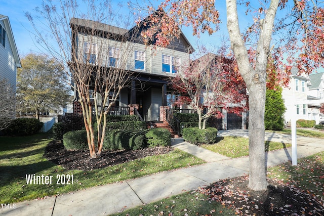 view of front facade featuring covered porch, a front lawn, and brick siding