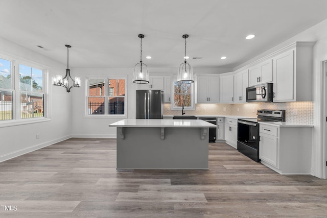 kitchen with white cabinetry, black appliances, light hardwood / wood-style flooring, and sink