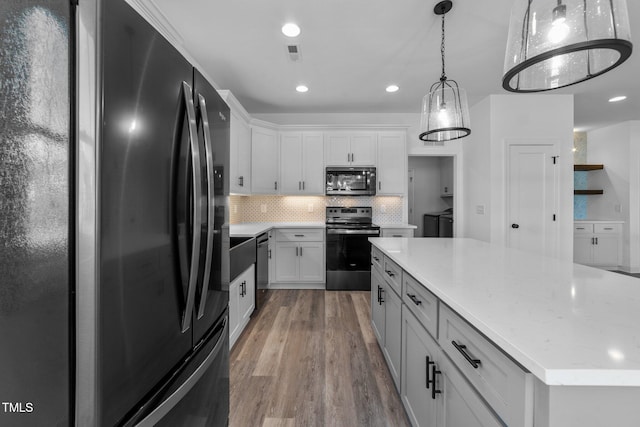 kitchen with backsplash, hardwood / wood-style floors, white cabinetry, stainless steel appliances, and pendant lighting