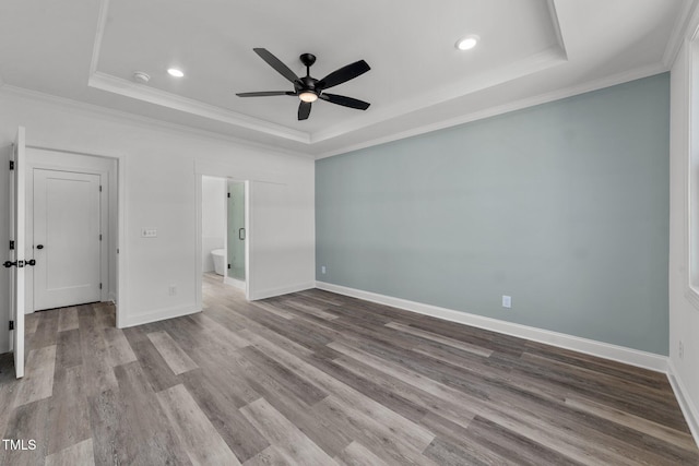 unfurnished bedroom featuring light hardwood / wood-style floors, ornamental molding, a tray ceiling, and ceiling fan