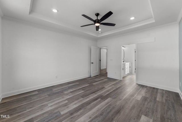 unfurnished bedroom with ornamental molding, dark hardwood / wood-style floors, a tray ceiling, and ceiling fan