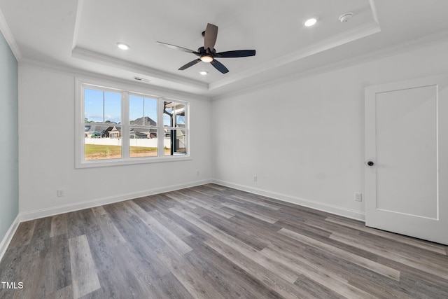 unfurnished room featuring ornamental molding, hardwood / wood-style flooring, a tray ceiling, and ceiling fan