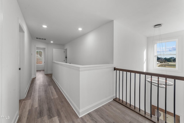 corridor featuring hardwood / wood-style floors and a notable chandelier