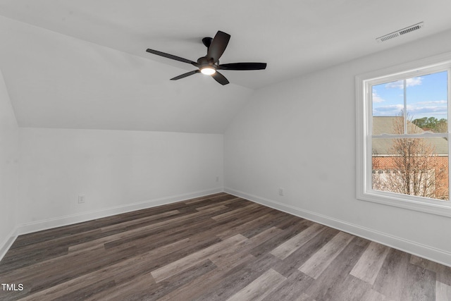 additional living space featuring vaulted ceiling, ceiling fan, plenty of natural light, and dark hardwood / wood-style flooring