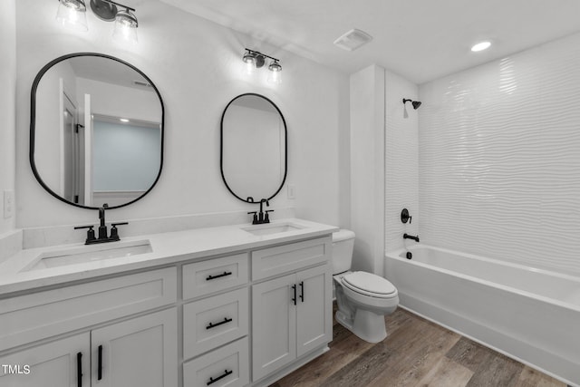 full bathroom with vanity, toilet, hardwood / wood-style floors, and tiled shower / bath