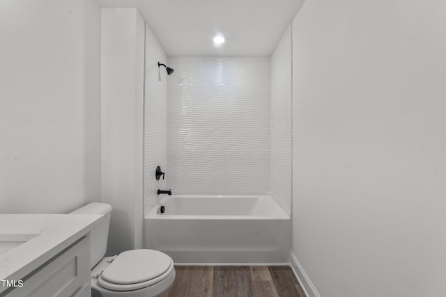 full bathroom featuring vanity, tiled shower / bath combo, hardwood / wood-style flooring, and toilet