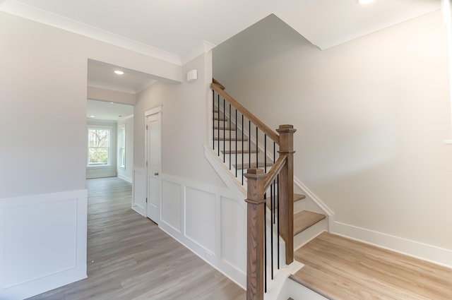 staircase featuring hardwood / wood-style flooring and ornamental molding