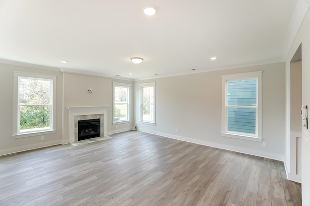 unfurnished living room with crown molding and light hardwood / wood-style flooring