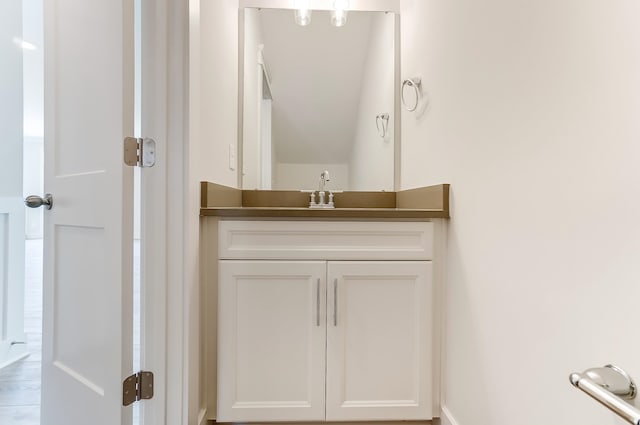 bathroom with vanity and lofted ceiling