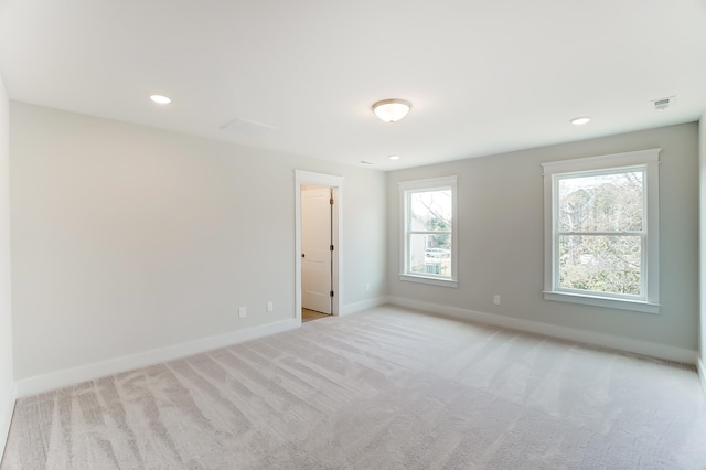 spare room with light colored carpet and a wealth of natural light