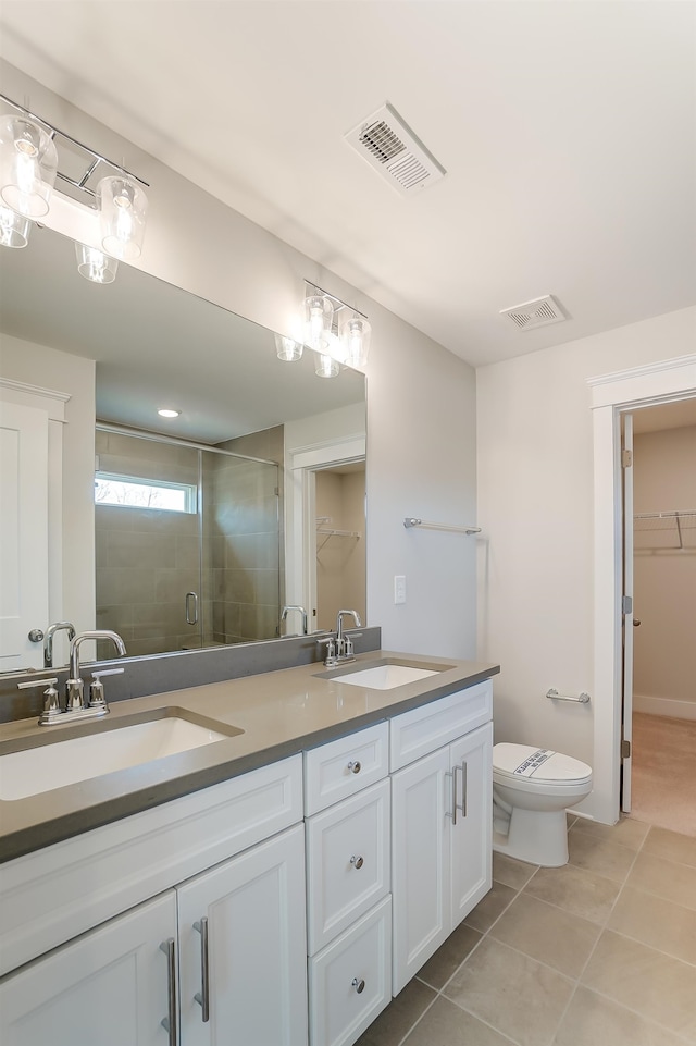 bathroom featuring vanity, a shower with shower door, toilet, and tile patterned flooring