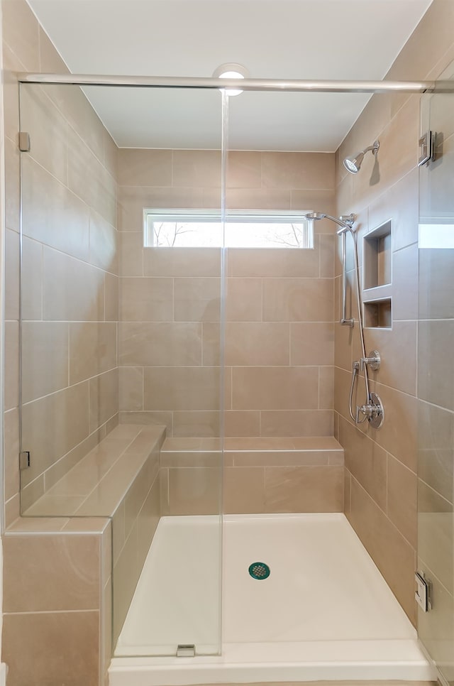 bathroom featuring a shower with door and plenty of natural light