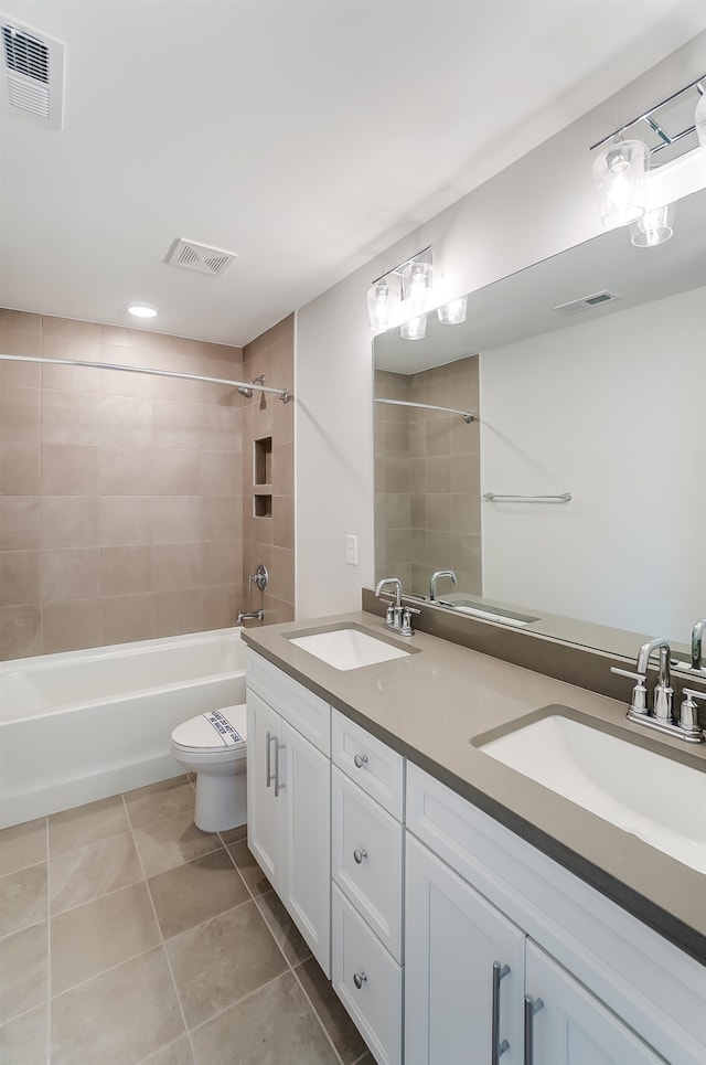 full bathroom with toilet, tiled shower / bath combo, vanity, and tile patterned floors