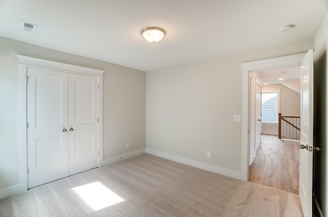 unfurnished bedroom featuring light hardwood / wood-style flooring and a closet