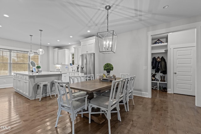 dining space with dark wood-type flooring and a chandelier