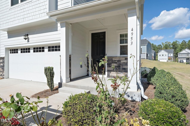 doorway to property with a garage and a porch