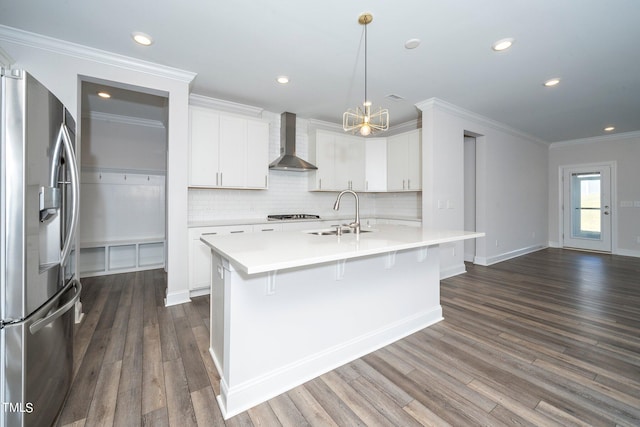 kitchen with dark hardwood / wood-style flooring, wall chimney range hood, stainless steel appliances, and white cabinets