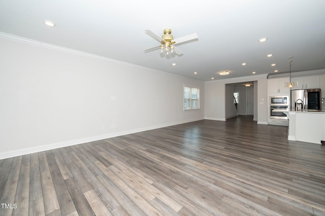 unfurnished living room with ceiling fan, crown molding, and dark hardwood / wood-style flooring