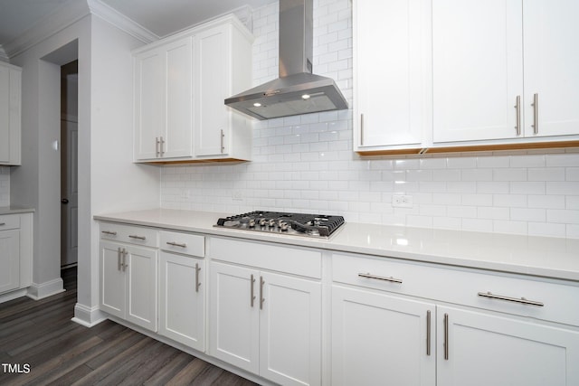 kitchen with white cabinets, tasteful backsplash, wall chimney exhaust hood, stainless steel gas stovetop, and dark hardwood / wood-style flooring