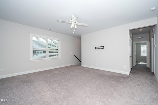 carpeted empty room with ceiling fan and a wealth of natural light