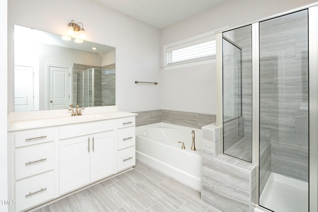 bathroom featuring vanity and independent shower and bath